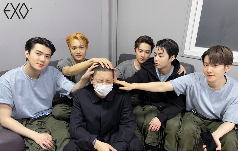 原来MV拍摄日，灿烈（左三）剃了平头，成员世勋（左起）、Kai、D.O.、Xiumin及伯贤重现摸头杀画面。