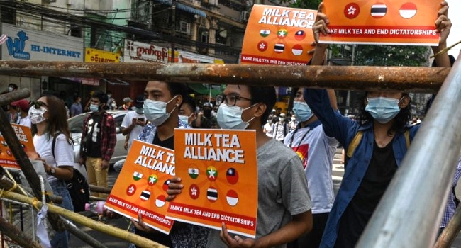 Protesters hold signs relating to the 