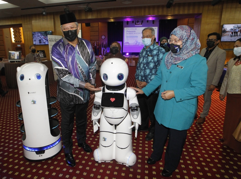 安努亚慕沙（前排左起）和罗希达在会上与其中一部机器人互动。后排左为马哈狄。


