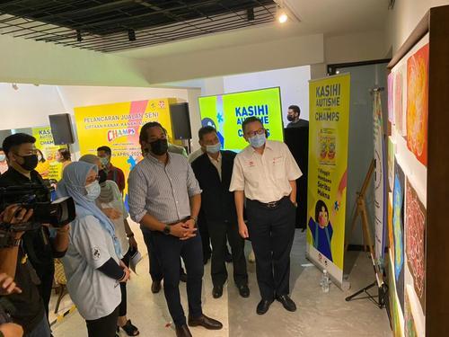 凯里（右三）在伦纳德阿里夫（右一起）和梅加阿末的陪同下，参观马来西亚国家自闭症协会展示的自闭症儿童所画的画作。