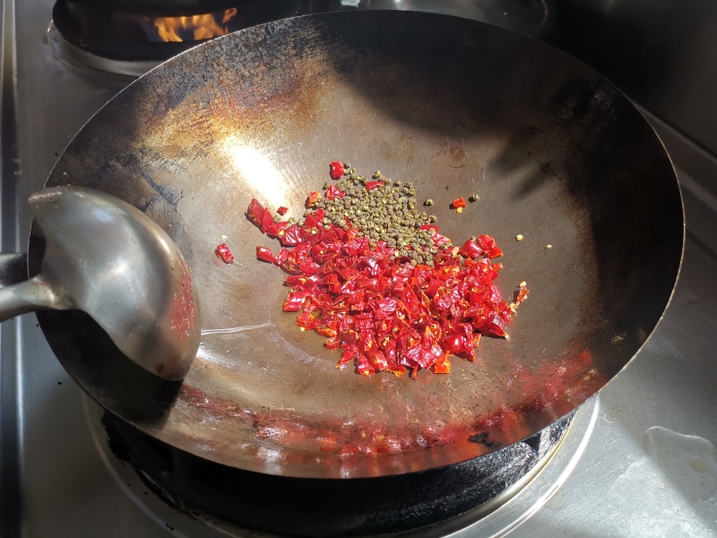 重新起锅，倒入少量的植物油爆香葱、姜、蒜，然后加入花椒麻椒和辣椒翻炒，炒出香味后，放入事先炸好的鸡肉继续翻炒即可。