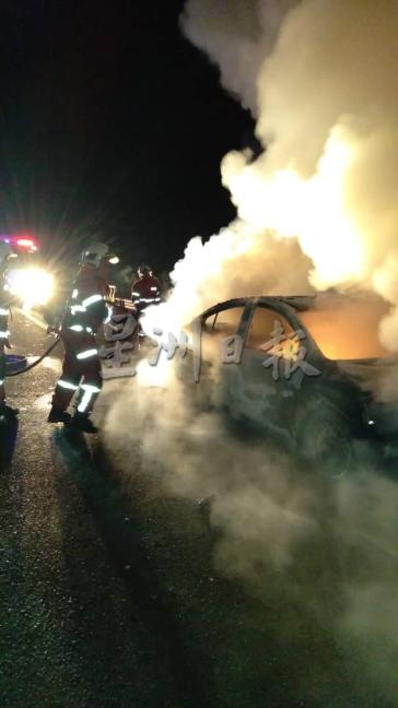 一辆行驶中的汽车突然起火燃烧，图为消拯员奋力灭火。