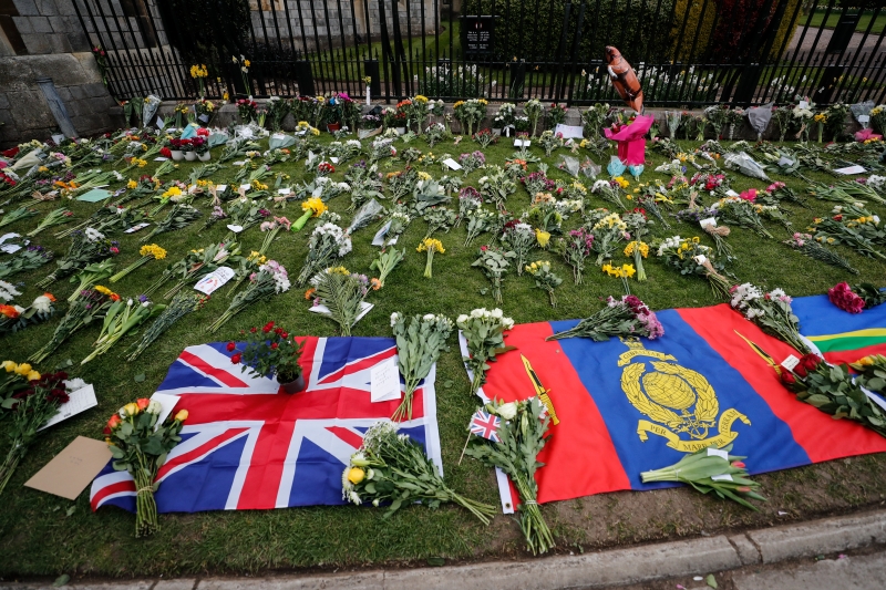 民众在白金汉宫外留下一束束鲜花和英国国旗。