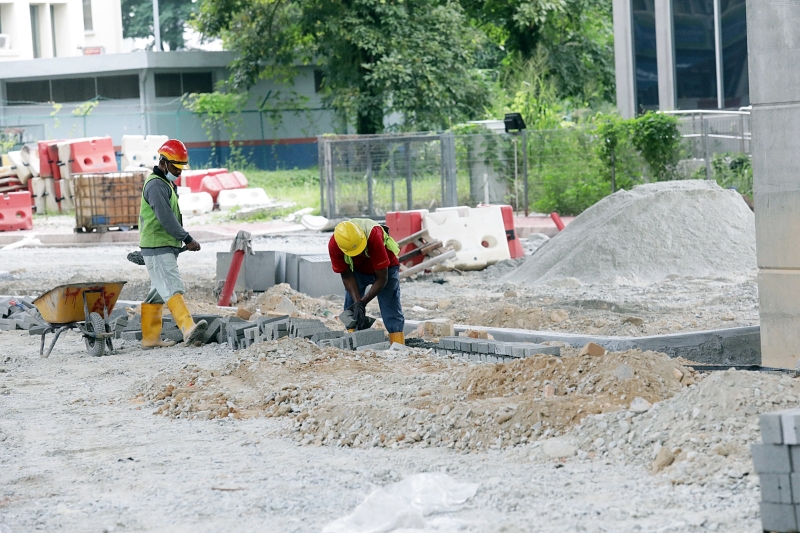 施工工人努力埋头苦干，希望可尽早完成铺路工程。