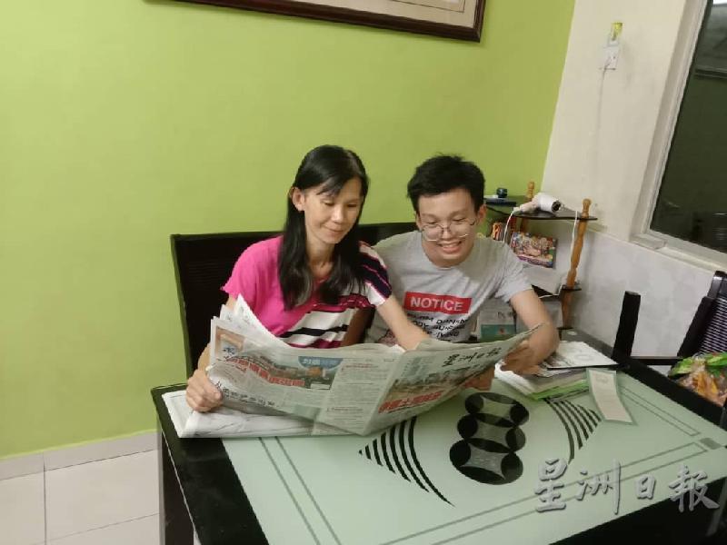 李汶俊与母亲一起享受阅报的时光。