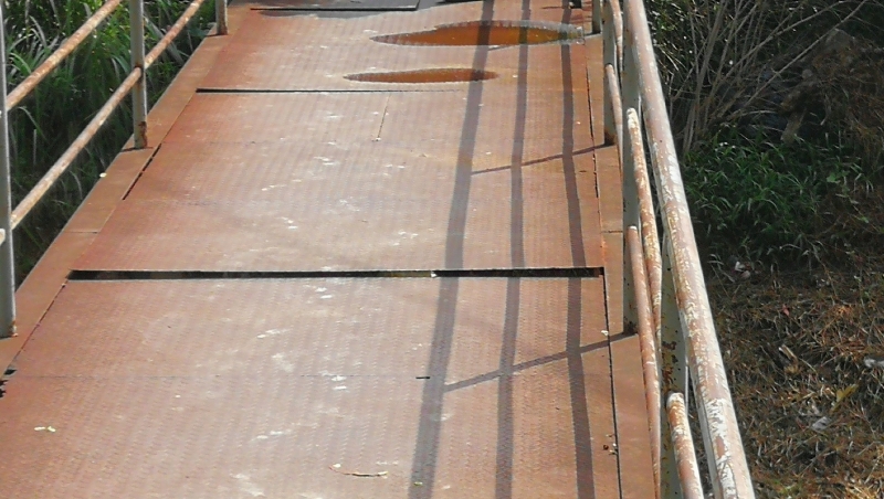 铁桥桥面的铁皮已出现缝隙及翘起来，路过的居民若没留意，很容易就会被绊倒。