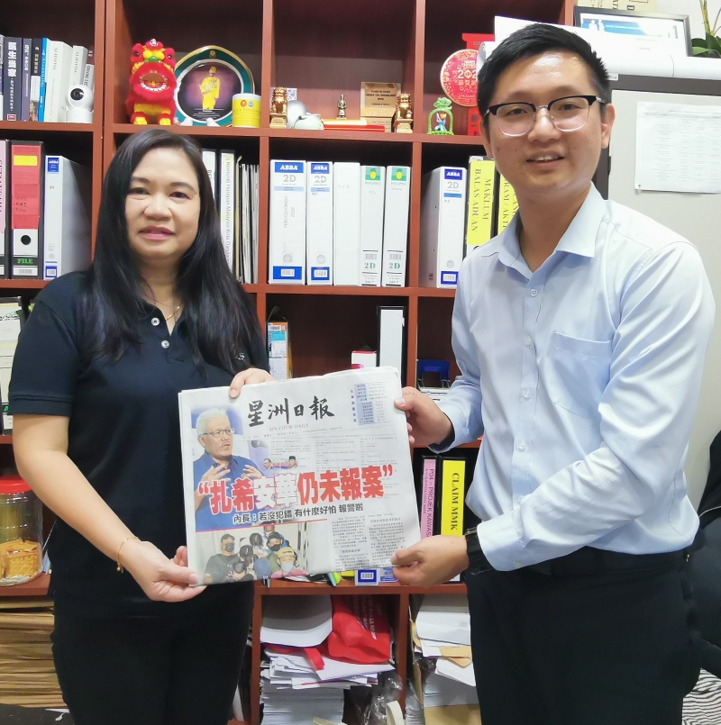 郑瑞隆（右）移交所赞助的《星洲日报》予4所学校，由张莲芝代表接领。