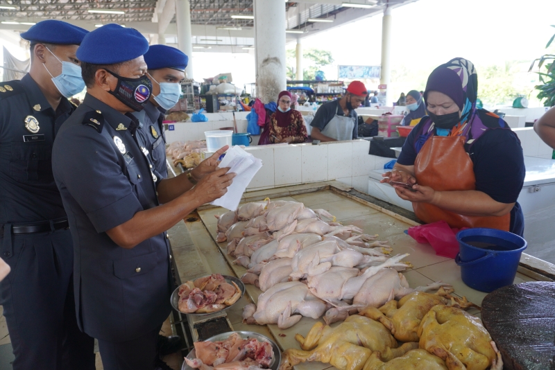 胡露丝娜扎（右）向玻州贸消局执法组出示肉鸡批发价调涨通知。
