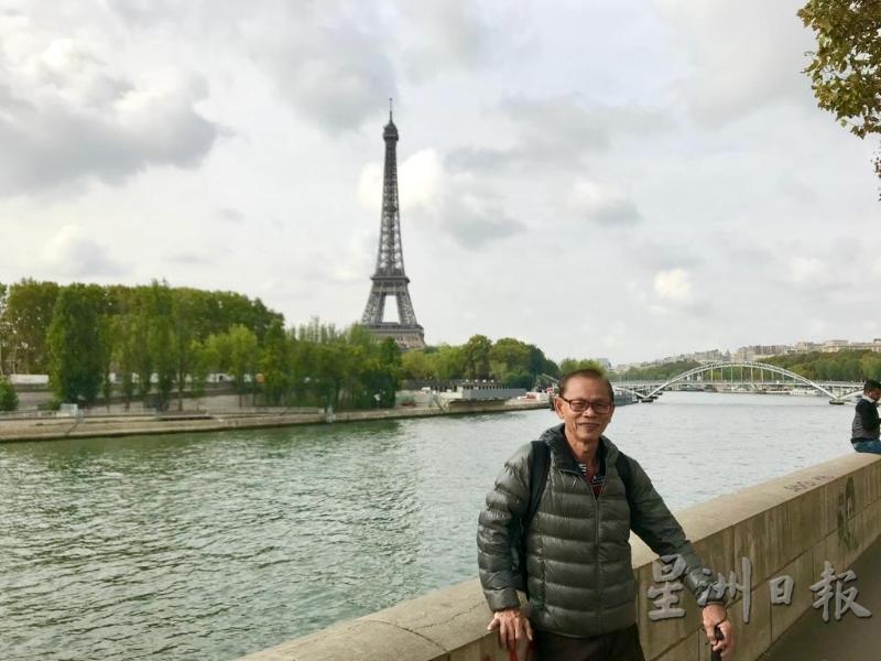 谢美德的后方是法国巴黎铁塔。