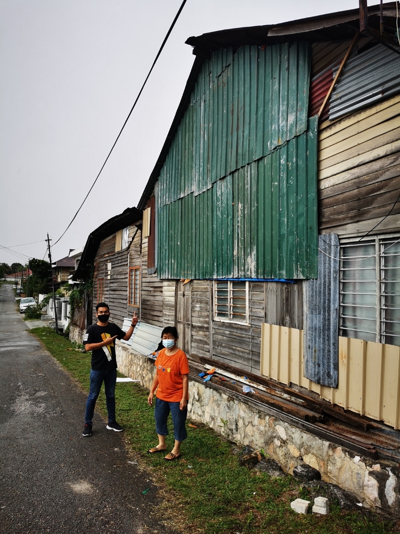 吴耀君（左）表示为独居妇人换上新锌片，防止雨水渗入家中。