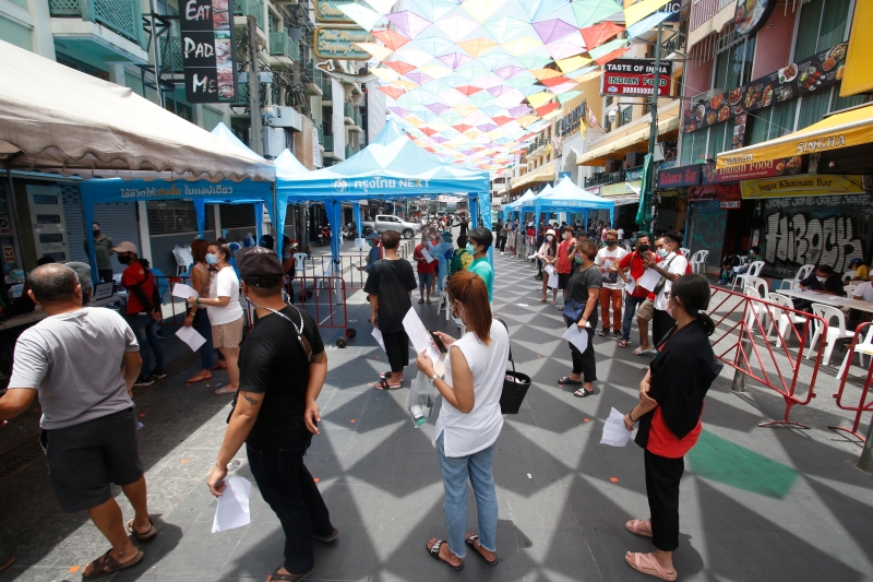 在深受背包客喜爱的曼谷考山路，民众排队等待接受冠病病毒检测，期间保持一公尺的安全社交距离。（美联社照片）

