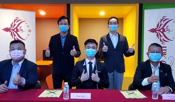 Teoh (center) at a press conference to share his story. On the extreme right is Zhu Quan Yun, principal of IPK College.