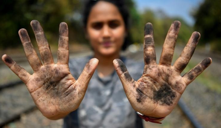 Zoologist Hycintha Aguiar shows her soot-covered hands after handling coal fallen onto railway tracks from a cargo train at the Kulem railway station in Goa. AFP