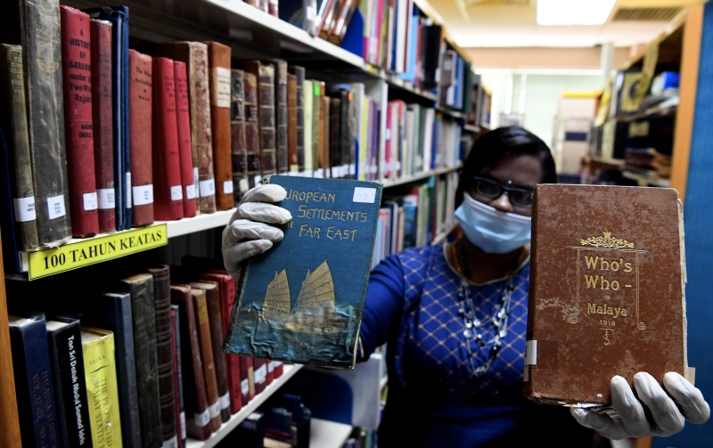 槟州公共图书馆机构助理卡莱威妮（34岁）展示超过100年历史的书籍。（图：马新社）


