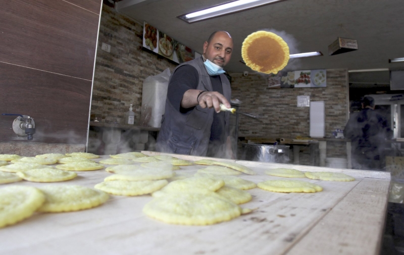 一名巴勒斯坦商贩在约旦河西岸城市纳布卢斯的一家市场制作传统甜食。