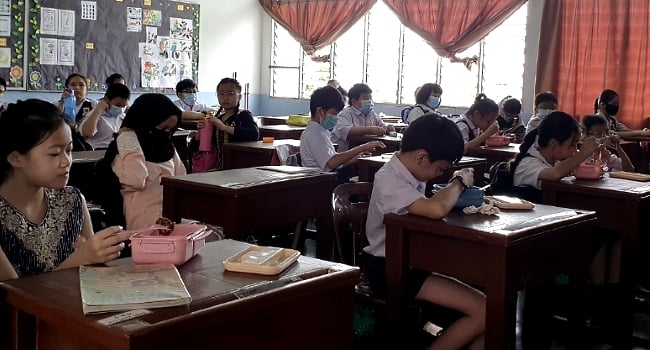 Pupils enjoying the treat offered by Puspa in their classroom.