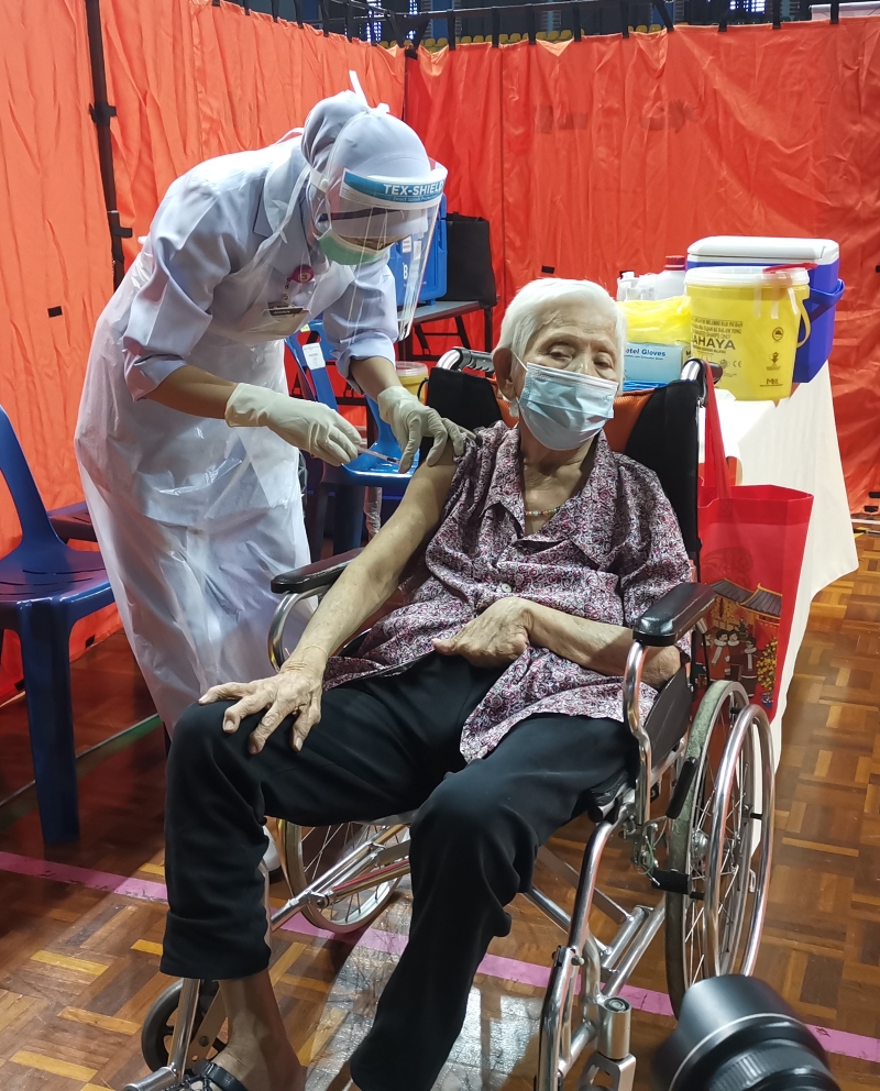 张秀凉（90岁）由孙子帮忙登记疫苗接种，并表示从没担心副作用。

