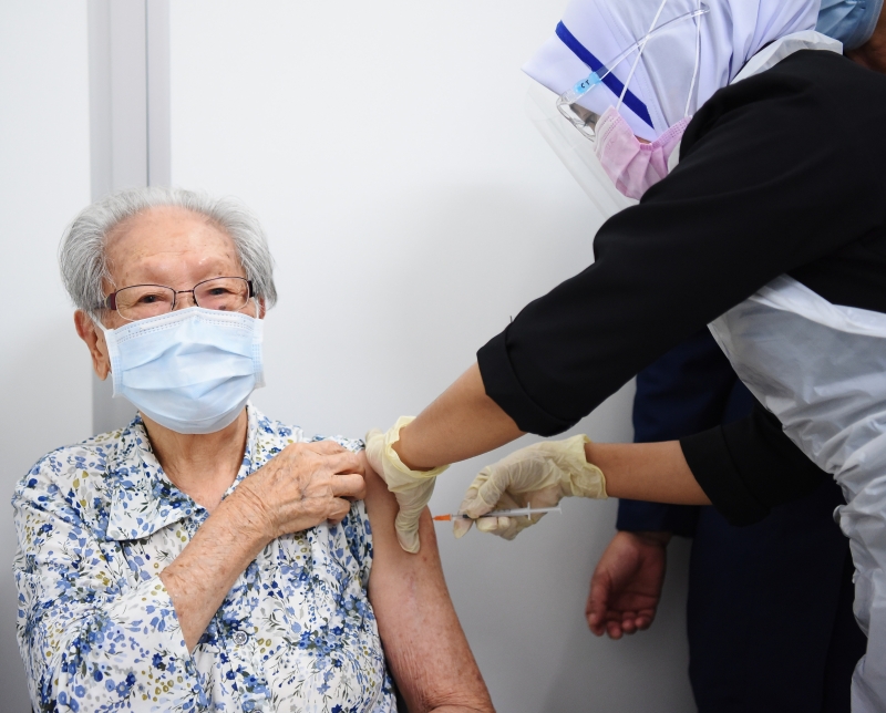 一名婆婆非常淡定的让医护人员为她注射疫苗。

