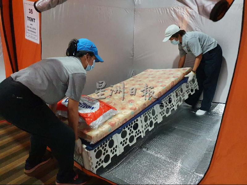 
志工将福慧床搬入隔离中心的帐篷内。