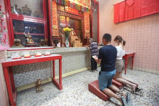 禀神是吉隆坡仙四师爷庙的特色，师傅正替两位信徒禀神。