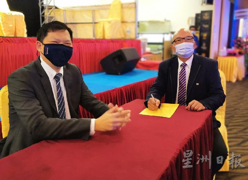 吴来富（右）签署就职书，正式成为新任会长。左为刘建祥。