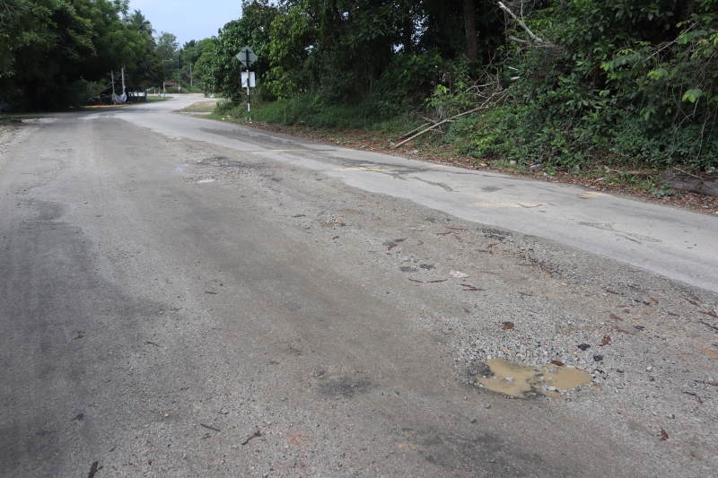 甘榜迪南路部分路段出现坑洞及柏油路已经变为砂石路。