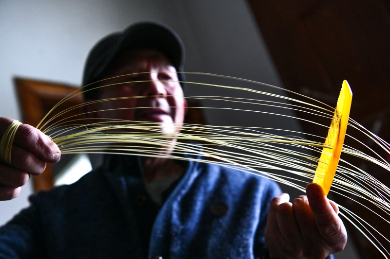 州省三穗县瓦寨镇坪城村的村民在用梳子梳理竹篾，为制作斗笠准备材料。（图 ：新华社）