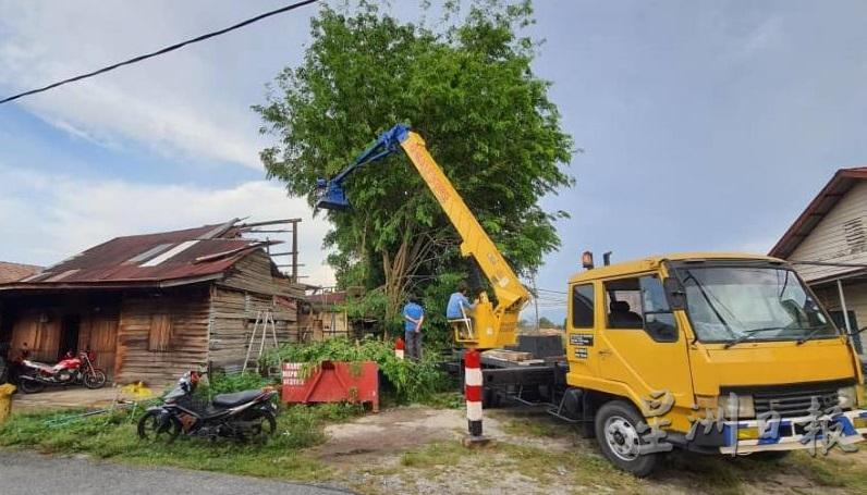 出动吊车砍倒树和修理遭暴风雨光顾的残旧破屋。