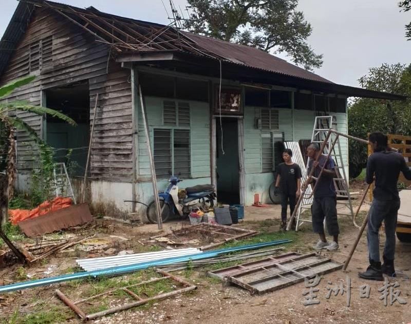 马来员工热心协助修理遭暴风雨打开大天窗的屋子。