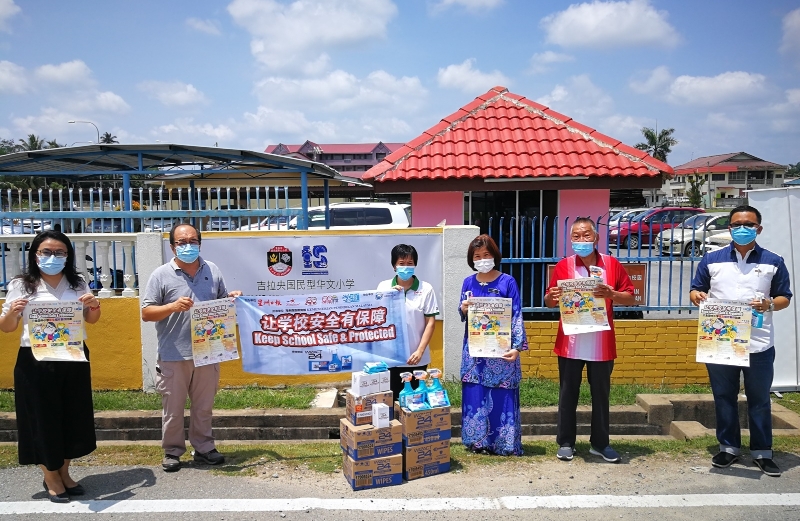 吉拉央华小：众人在消毒品移交仪式上高举活动海报和横幅合影，左起欧阳秀媚、陈启华、罗迓春、林洁慧、卢永绥、洪建达。