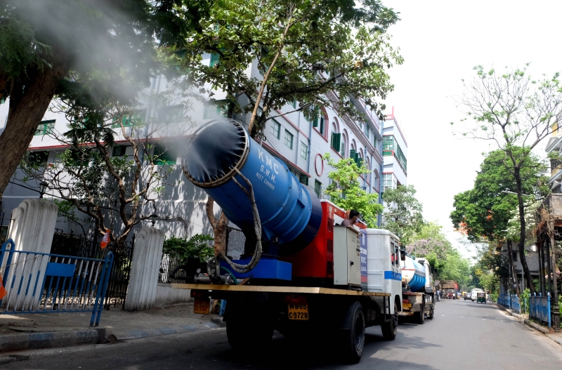 在加尔各答的街道上，市政局出动消毒作业车辆，遏止街头的冠病病毒蔓延。（新华社图片）