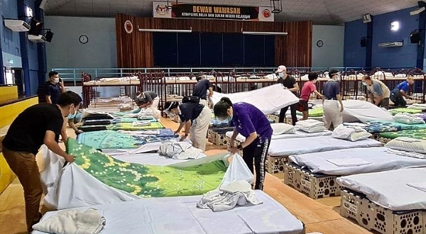 Volunteers setting up the multipurpose foldable beds. SIN CHEW DAILY