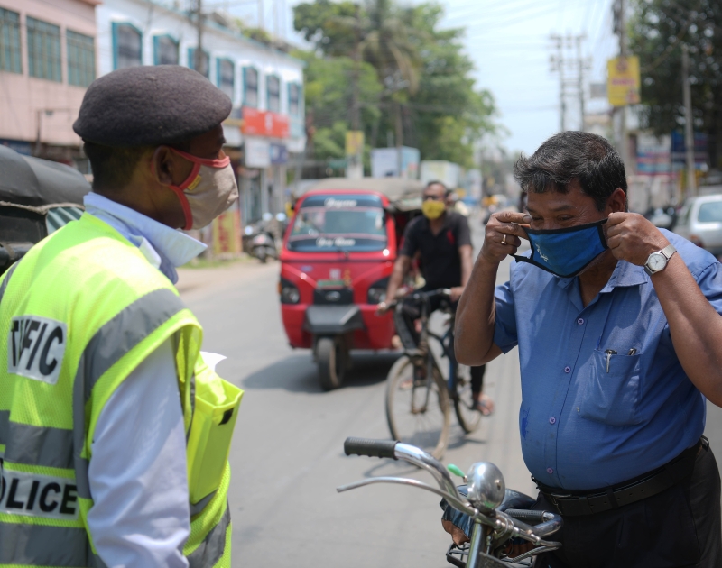 印度警方在街头取缔不愿戴上口罩的民众。（新华社图片）