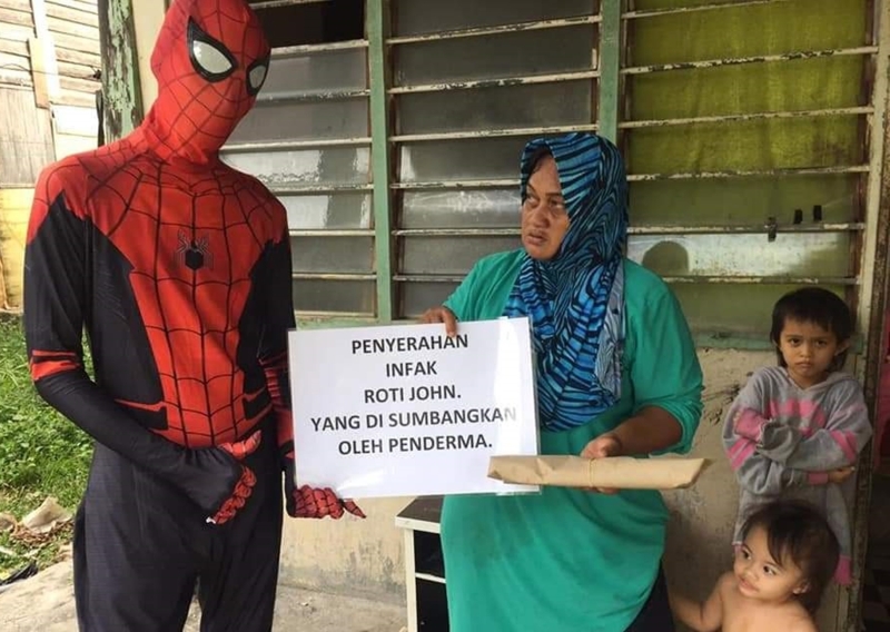“蜘蛛侠”将热心人士捐助的“约翰面包”，赠送给有需要的家庭。