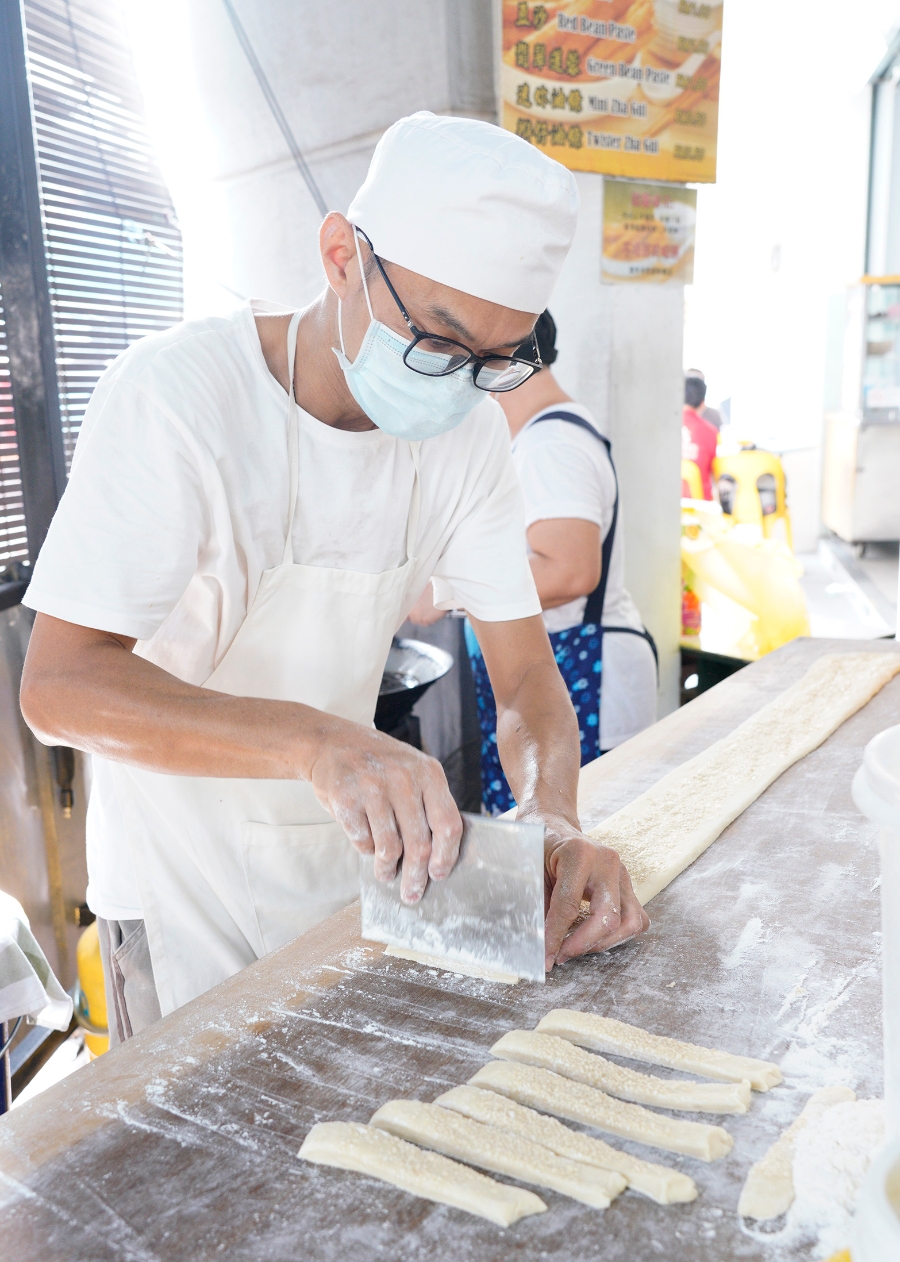 制作马脚，把表层抹上混合芝麻和麦糖芽的面粉团切成条状，下锅前再卷成“马脚”型。