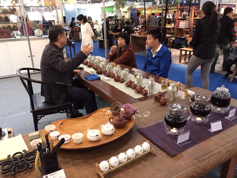 在台湾茶展上，客人以锡罐让茶聚味。