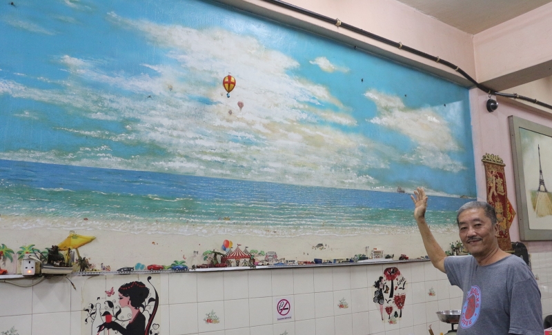 颜亚祥花2天时间在墙壁上绘画，使咖啡店拥有自己的特色。