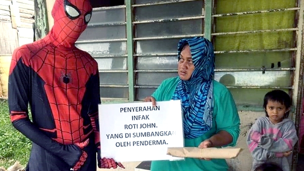 A Spiderman delivers Roti John sponsored by a good Samaritan to a poor family. A Spiderman delivers Roti John sponsored by a good Samaritan to a poor family.