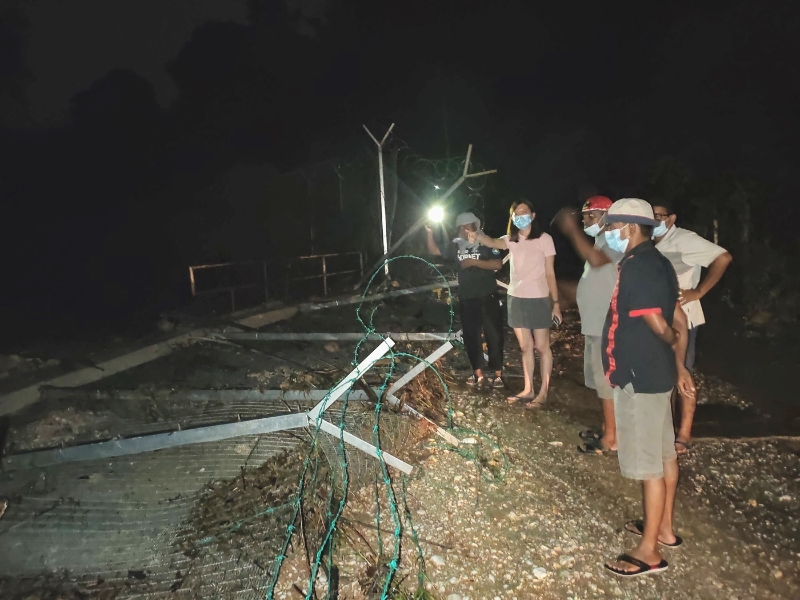 黄诗情（左二）与迪遮服务队和水利灌溉局官员前往视察附近务边河及水坝情况，发现河流洪水冲倒桥边篱笆。