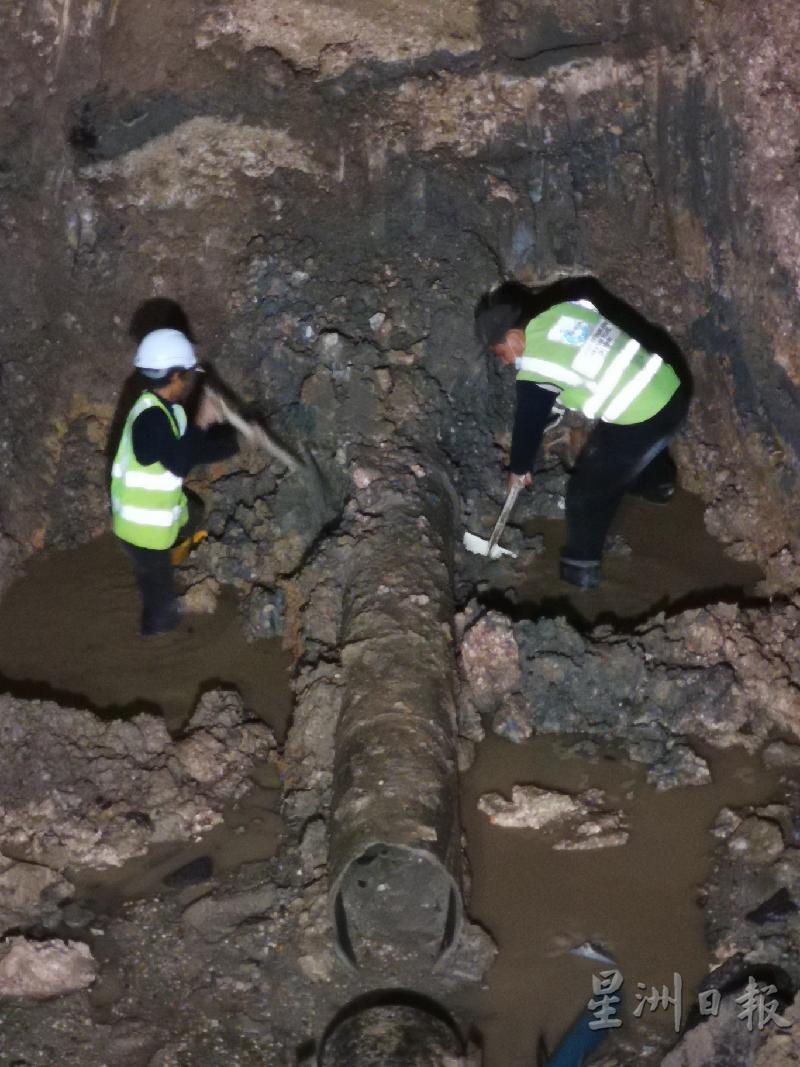 维修人员彻夜赶工清理坑洞的泥土，抓紧时间抢修水管。