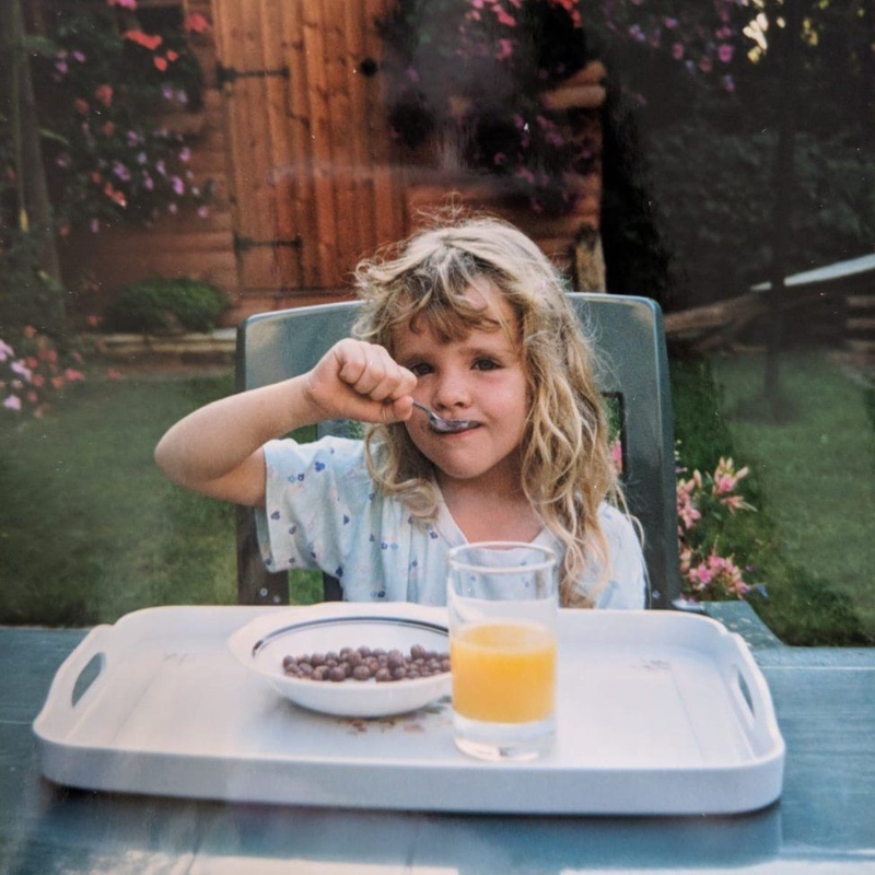 年幼的洛蕾塔在庭院享受祖母准备的食物。