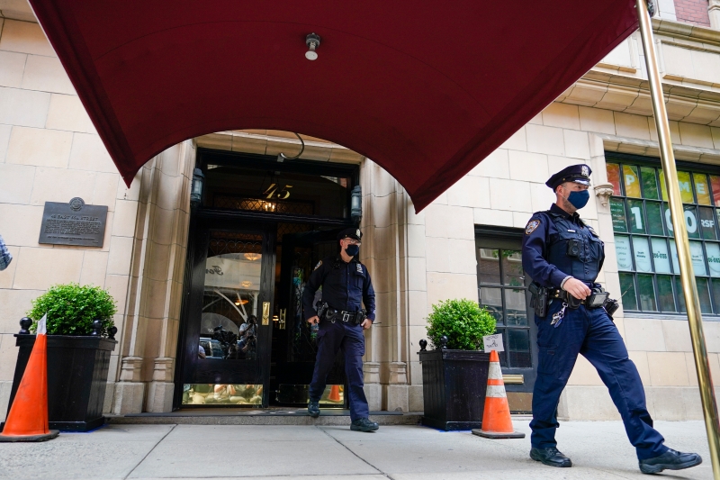 美国联邦调查局突击搜查，前总统特朗普私人律师朱利安尼的住所及办公室。在朱利安尼住的公寓外，周三早有警察走出来。（美联社照片）