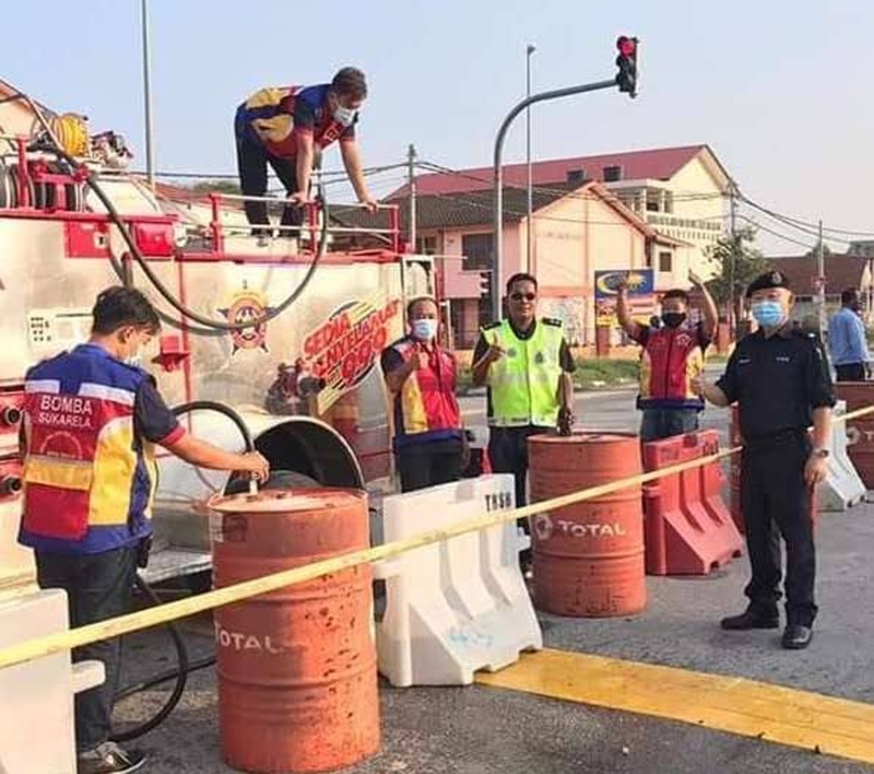 去年行管令期间，爱大华志愿消防队受警方之托，协助设置利用装满水的油桶来封锁路段。