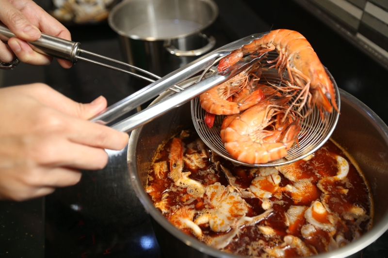 3.将事前汆烫的虾只及苏东放入东炎汤内，并加入几片疯柑叶即可。