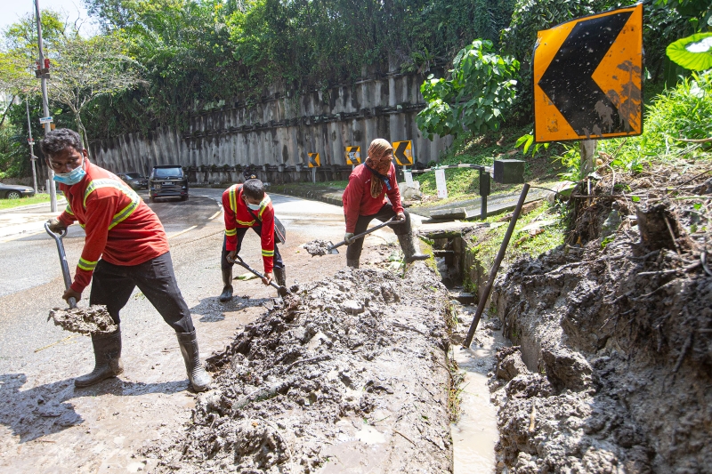 环卫工人清理淤泥，疏通水沟。