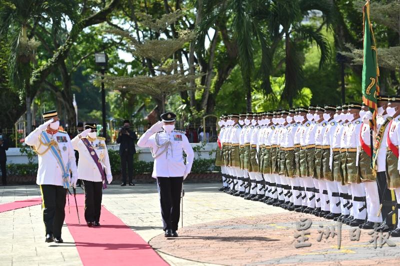 新任槟州元首敦阿末弗兹（左二）检阅皇家马来兵团队伍。