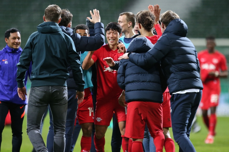 韩国前锋黄喜灿（中）在德国杯半决赛助莱比锡打入一球，图为他在赛后结束后与队友和工作人员庆祝球队闯入决赛。

