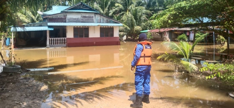 民防部队队员在甘榜双溪篮南百地区观察水势，水未消退，灾民还未回返家园。