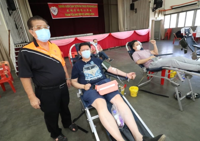 捐血达人陈伟煌到怡保中国精武体育会的捐血活动上捐血，获得会长拿督黄保生（左）赞赏。
