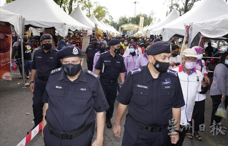 米奥法立（右）联同警官巡视怡保英迪拉慕丽亚斋戒月市集以确保小贩和民众都有遵守SOP。左为马兹兰。